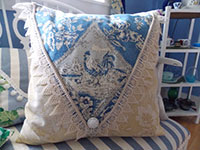 Image of a blue and white toile pillow.