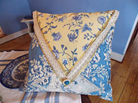 Image of a blue and yellow toile pillow.